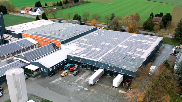 Luftaufnahme eines Gewerbegebäudes mit Photovoltaikanlage auf dem Flachdach